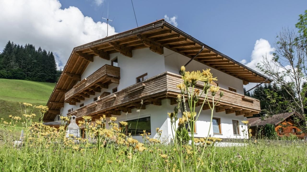 An Austrian-style guest house surrounded by wildflowers, fields, and trees